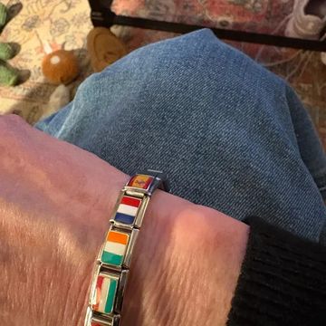 Women wearing a silver italian charm bracelet with multiple country flags
