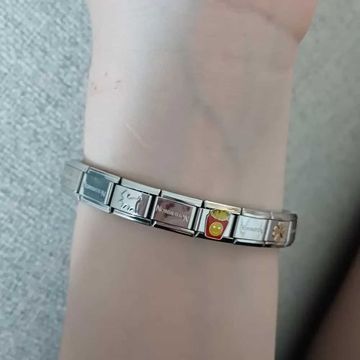 Silver Italian charm bracelet with multiple Nomination links, featuring decorative charms including a sun, a red box of fries with a yellow smiley face, and a flower